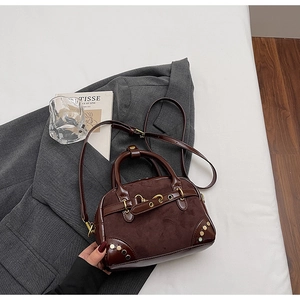 Detail of vintage brown Boston bag featuring metal studs and mixed leather texture