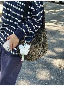 Détail du sac bandoulière en toile léopard avec charm lapin et bandoulière réglable