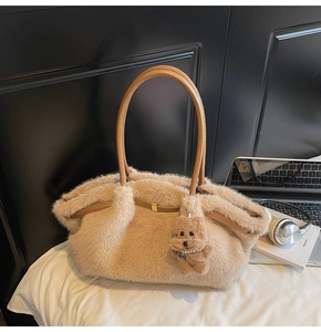 Dettaglio borsa shopper in peluche con manici in pelle e ciondolo a forma di orsetto