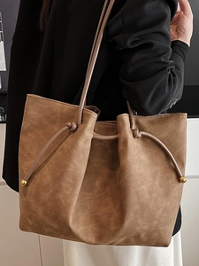 Retro brown large capacity tote bag with drawstring closure and gold metal ball detail