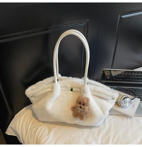 Dettaglio della borsa tote in peluche bianco con texture morbida e ciondolo a cucciolo