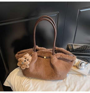 Dettaglio di una borsa tote in peluche marrone con trama in ecopelliccia e manico in pelle