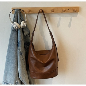 Detailansicht der braunen Hobo-Beuteltasche aus weichem Kunstleder mit breitem Gurt