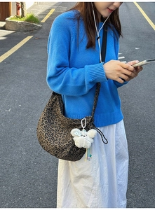 Détail d'un grand sac cabas à imprimé léopard avec une jolie peluche de lapin blanc