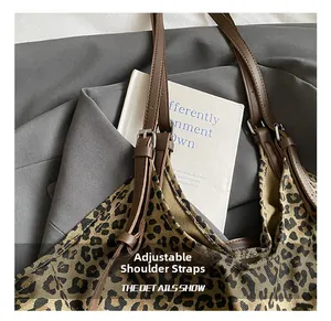Detail show of adjustable brown leather strap and silver buckle on leopard print tote bag
