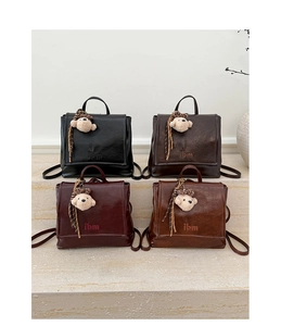 Four vintage faux leather backpacks in black, coffee, burgundy, and tan with bear charms