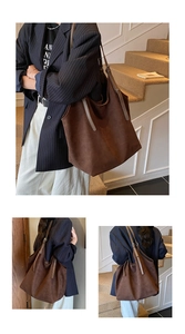 Macro view of a large brown suede tote bag showing soft texture and vintage minimalist style