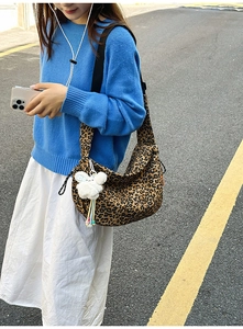 Photo en plein air d'un grand sac hobo léopard avec un charm et une bandoulière