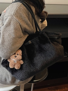 Borsa tote chic in ecopelliccia nera con manici in pelle e ciondolo a forma di cucciolo