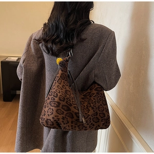 Detailed view of leopard print tote bag texture and slouchy design on female model