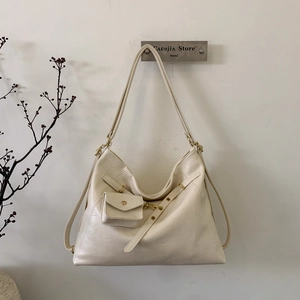 Detail of off-white leather tote bag with vintage gold hardware and detachable mini pouch