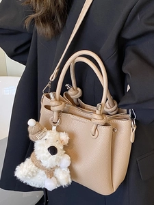 Elegant apricot lychee leather handbag with knot handles and cute puppy charm for women