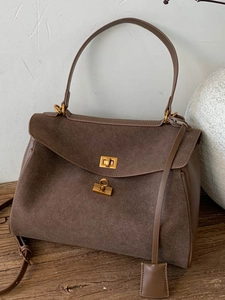 Retro brown suede tote bag with golden lock on vintage wooden table for 14-inch laptops