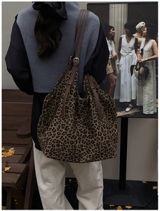Leopard print suede tote bag with brown leather straps shown in an autumn street setting