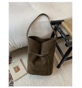 Detailed texture of high-quality dark olive suede on a large capacity bucket shoulder bag