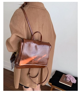 Detail of vintage brown oil-wax leather backpack with debossed logo for winter style