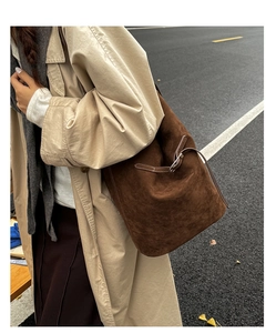 Macro shot of dark brown matte suede bucket bag with adjustable silver buckle detail
