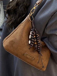 Brown suede shoulder bag with retro wooden bead tassel and elegant metal plaque
