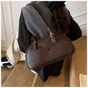 Detail view of coffee brown lychee grain leather bowling bag with gold hardware buckle