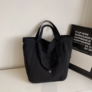 Macro shot of durable black nylon fabric and circular logo on large tote bag
