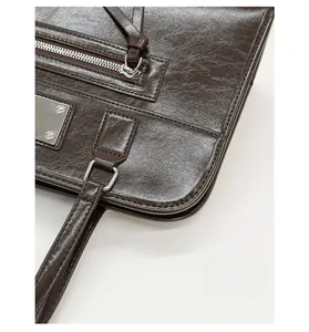 Detailed macro view of dark brown leather texture with silver zipper and metal hardware