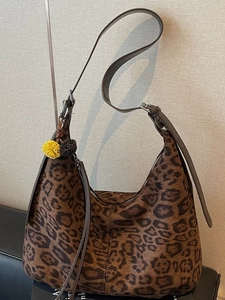 Classic leopard print hobo bag with adjustable brown shoulder strap and fuzzy pompom charm