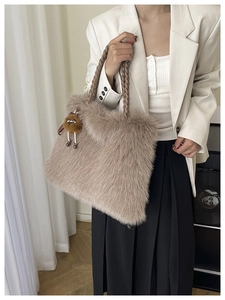 Detail of soft khaki plush tote bag featuring woven handle and cute bear charm accent