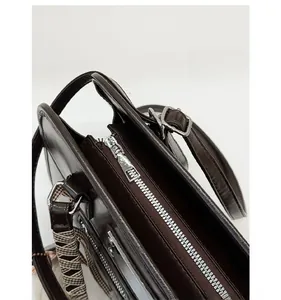 Detail of premium silver zipper and hardware on deep brown polished leather handbag