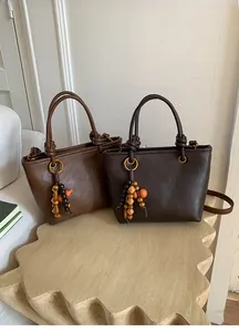Detailed view of vintage brown tote bags with knot handles and wooden bead ornaments