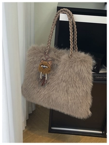 Close-up of fluffy faux fur tote bag with woven rope handles and a cute monster charm