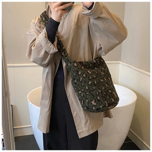 Détail du sac seau en peluche à motif léopard vert avec large bandoulière souple