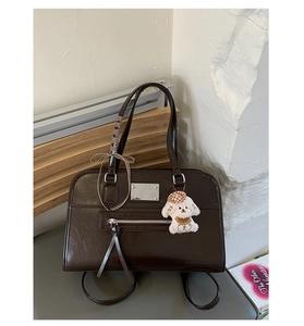 Detailed view of deep brown vintage tote bag with glossy finish and cute puppy charm