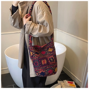 Gros plan du sac seau en peluche bohème avec des motifs géométriques tricotés colorés