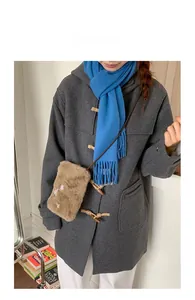 Petit sac bandoulière en peluche marron porté avec manteau gris et écharpe bleue