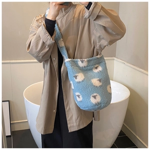 Vue détaillée du sac seau en peluche bleu ciel avec motif de mouton et texture douce