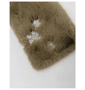 Gros plan sur tissu peluche marron avec broderie détaillée de flocons et de pattes