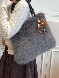 Fashionable grey faux fur tote bag with black woven handles and brown pompom charm