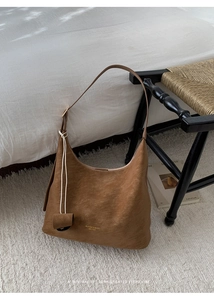 Detail of vintage brown leather Hobo bag with adjustable strap and golden logo text