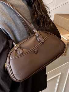 Retro dark brown leather bowling bag shown on shoulder for a chic commute style