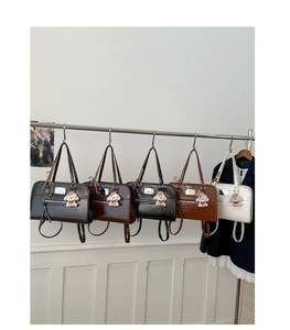 Detail view of retro glossy leather tote bags in various colors with cute plush pendants