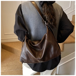 Detail shot of vintage dark brown tote bag with oily leather texture and fine stitching