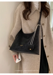 Detail of vintage black tote bag with white contrast stitching and a mini hanging pouch