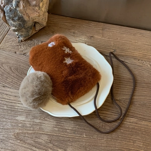 Détail du petit sac bandoulière en peluche marron avec broderie flocon et pompon gris