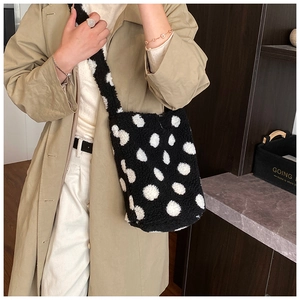 Détail de la texture en peluche à pois noirs et blancs du sac seau et de sa bandoulière