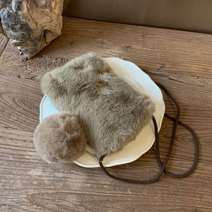 Détail d'un petit sac bandoulière en peluche kaki avec broderie flocon et pompon doux