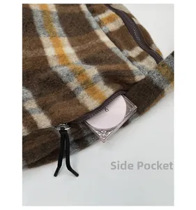 Detail view of the side zipper pocket on a brown plaid wool tote bag showing storage depth