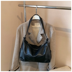 Detail of black vintage hobo bag showing cross stitching and smooth matte leather texture