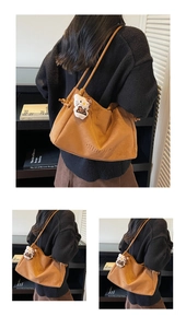 Gros plan sur un sac cabas vintage en daim marron avec logo embossé et grande capacité