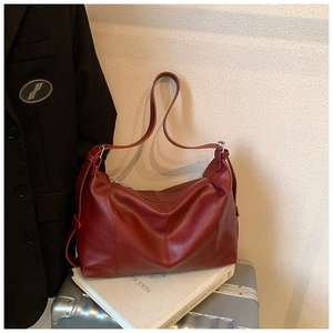 Detailed view of the burgundy shoulder bag featuring soft leather texture and premium stitching