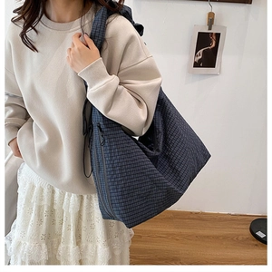 Detail of blue and black checkered tote bag showing large capacity and soft fabric texture